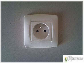 Plaque de finition posée sur une prise électrique encastrée