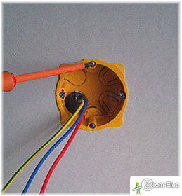 Début de fixation d’un boîtier d’encastrement par vissage d’un étrier sans serrage excessif